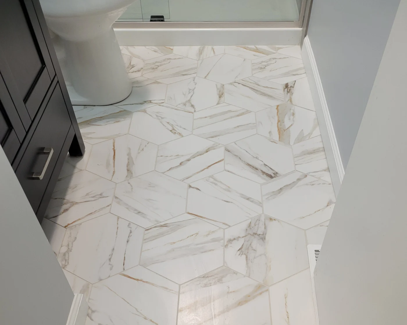 Mast Contracting Makes Changes Work During Interior Remodeling A section of a bathroom floor redone by Mast Contracting with hexagonal marble tile.