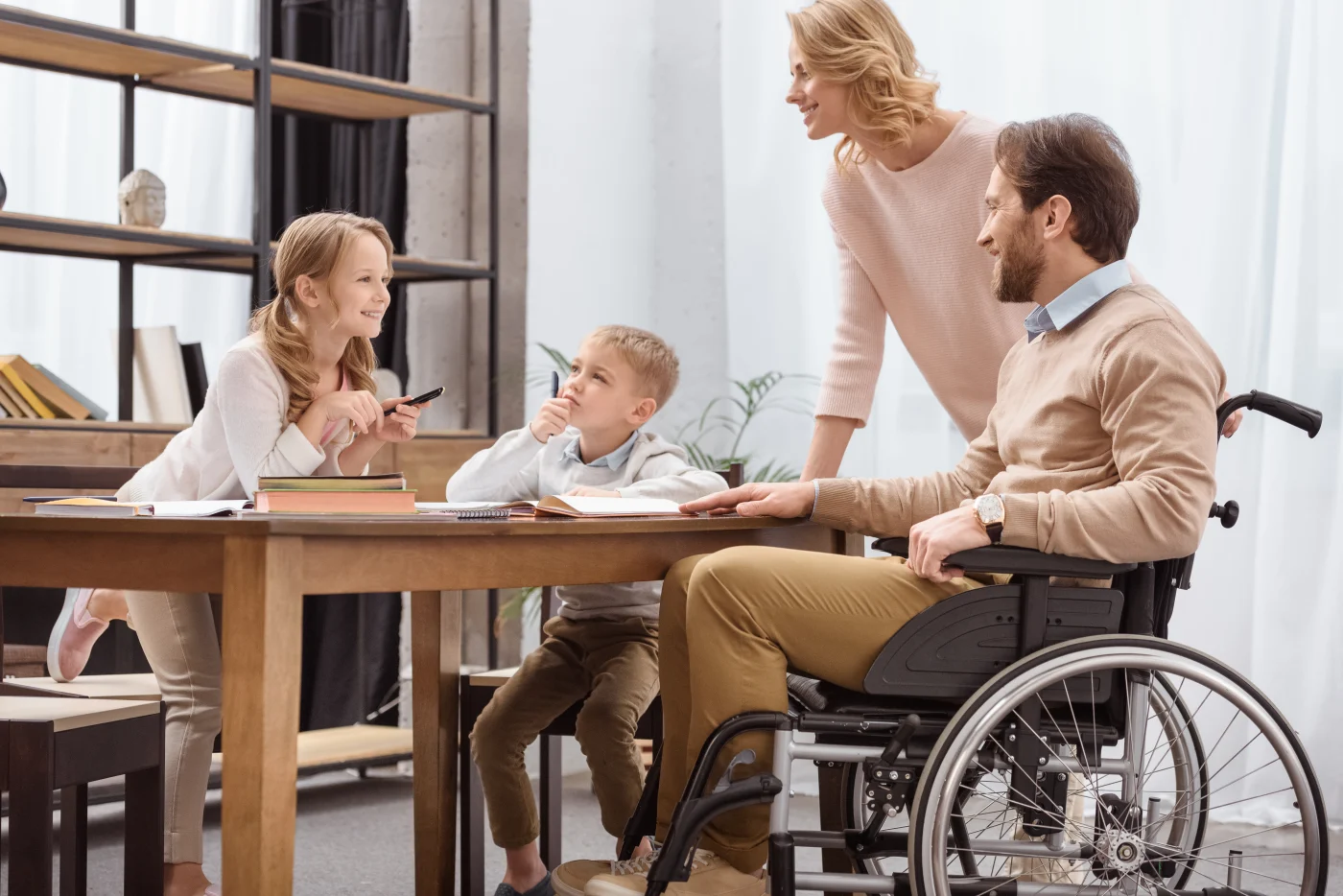 Family at kitchen table, father in wheelchair