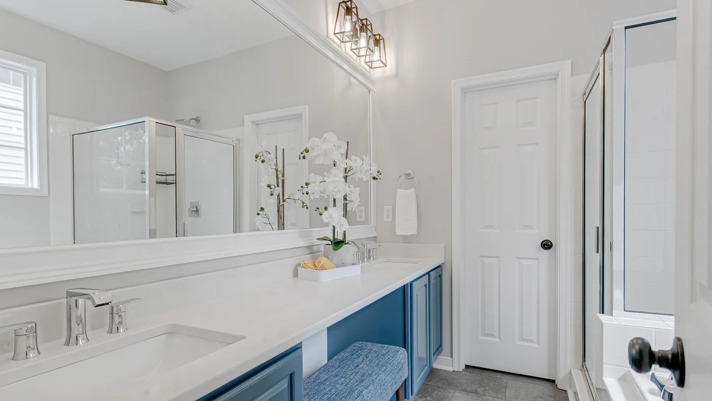 Beautiful white bathroom remodel with large mirror and white countertops