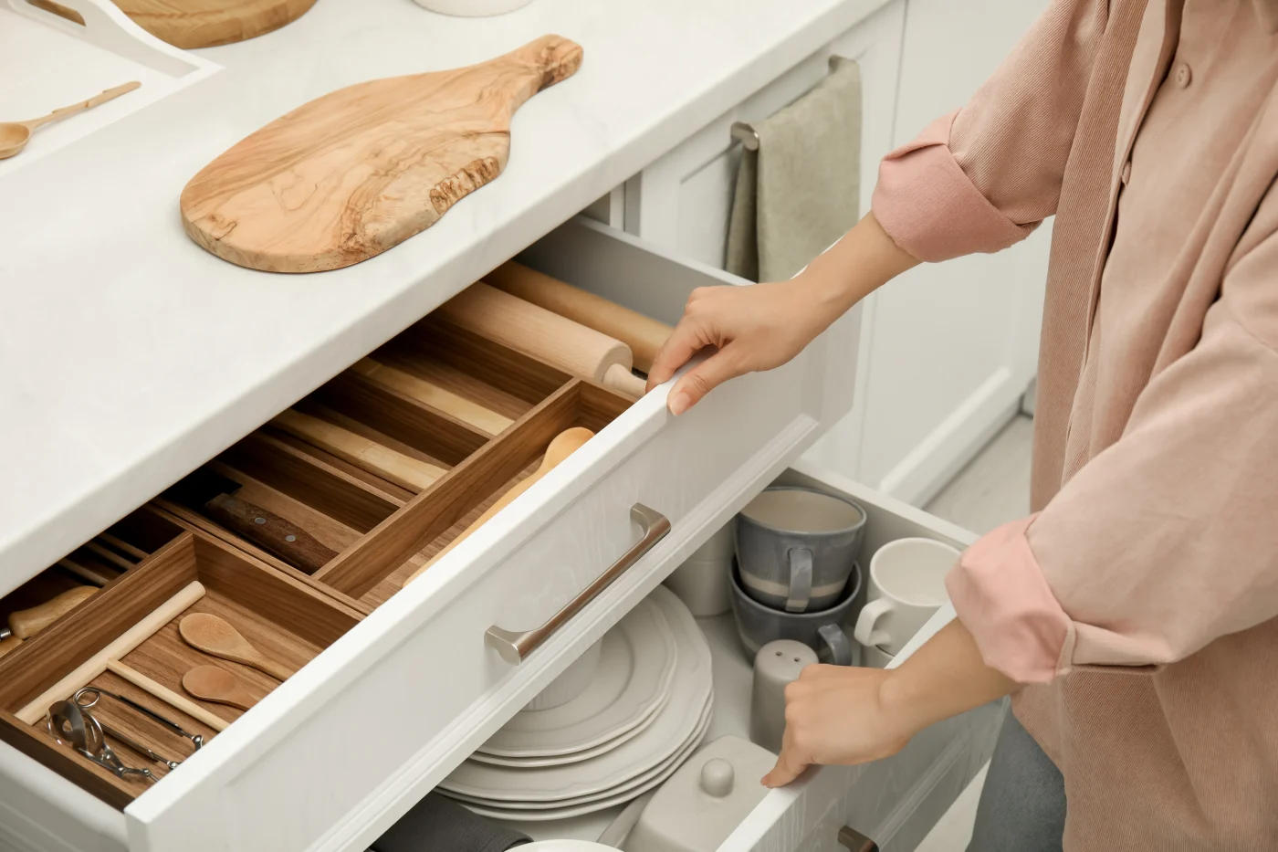 Woman opening utensil drawer in remodeled kitchen