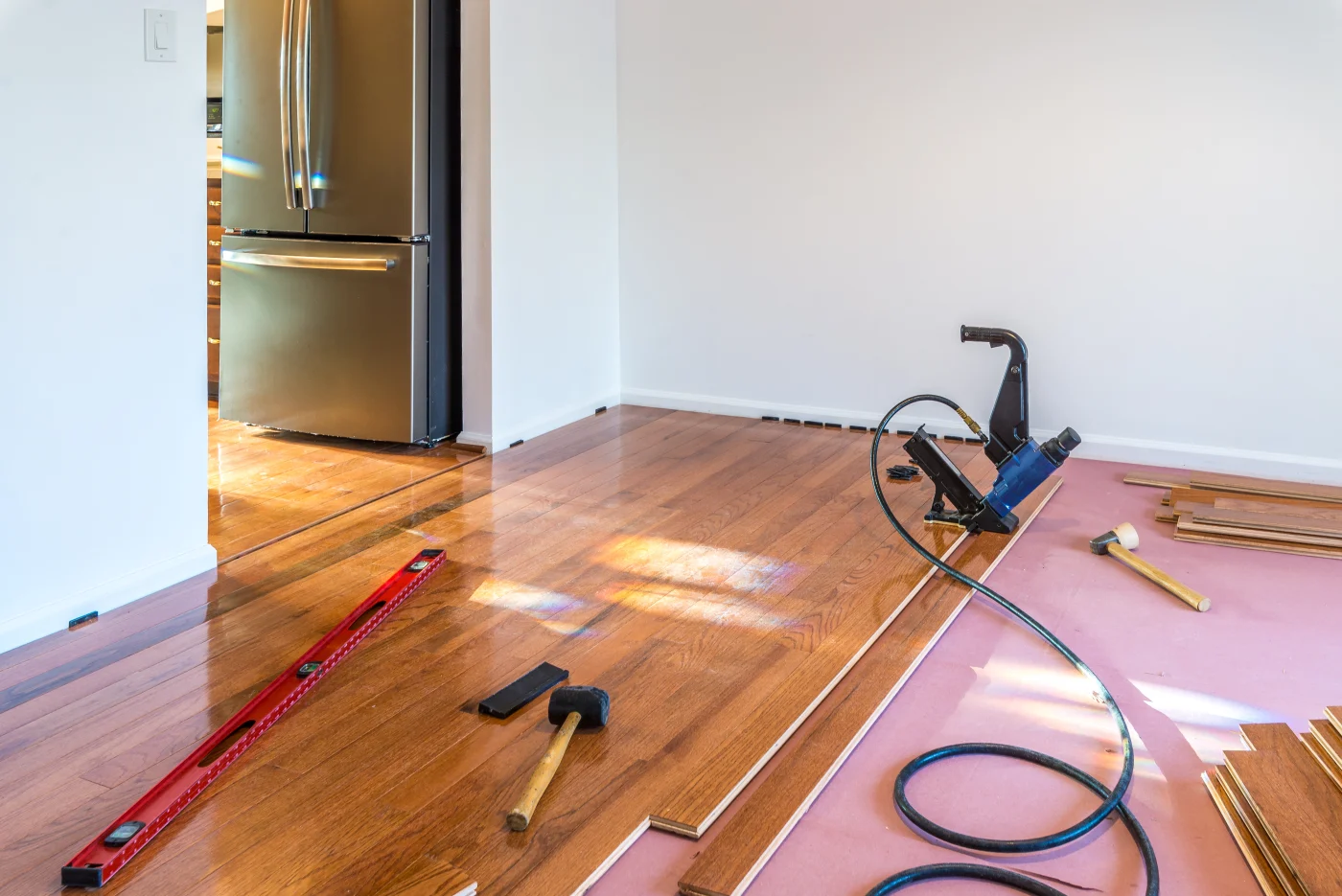 New hardwood flooring being laid down in dining room of home