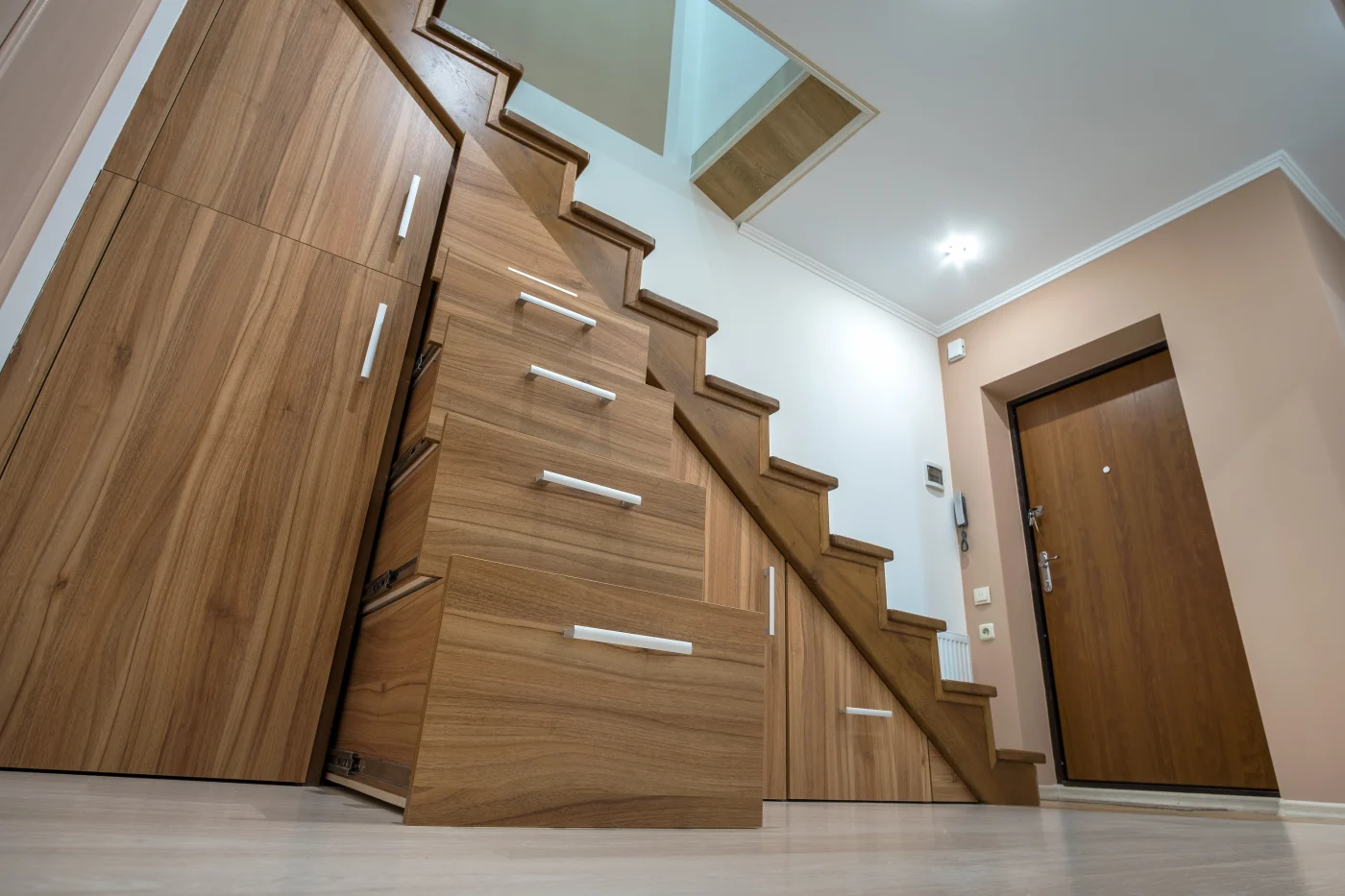 Updated stairs in home that include storage solutions in area underneath stairs