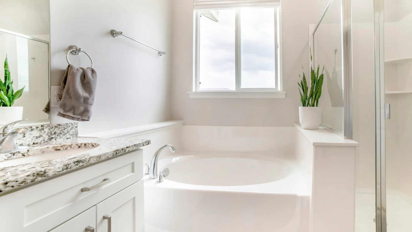 Round white garden tub in newly remodeled bathroom with white vanity
