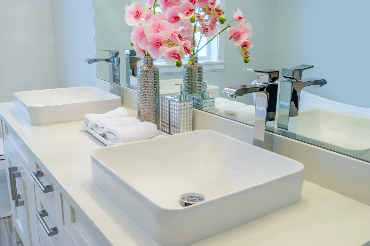 Updated vanity in bathroom with square sinks and faucets