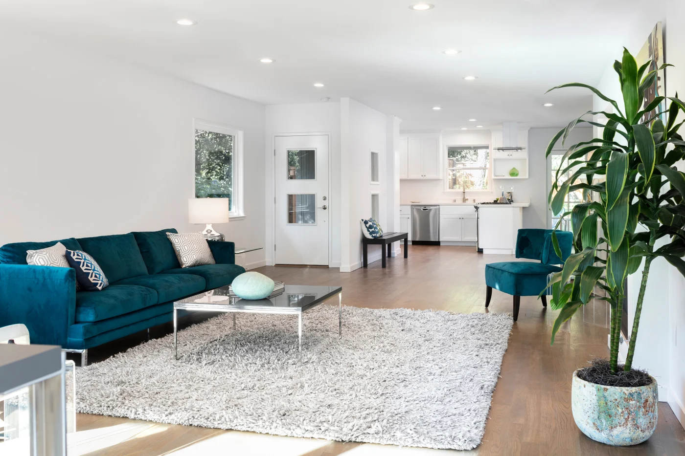 Living room with a furry area rug, blue furniture, and a table