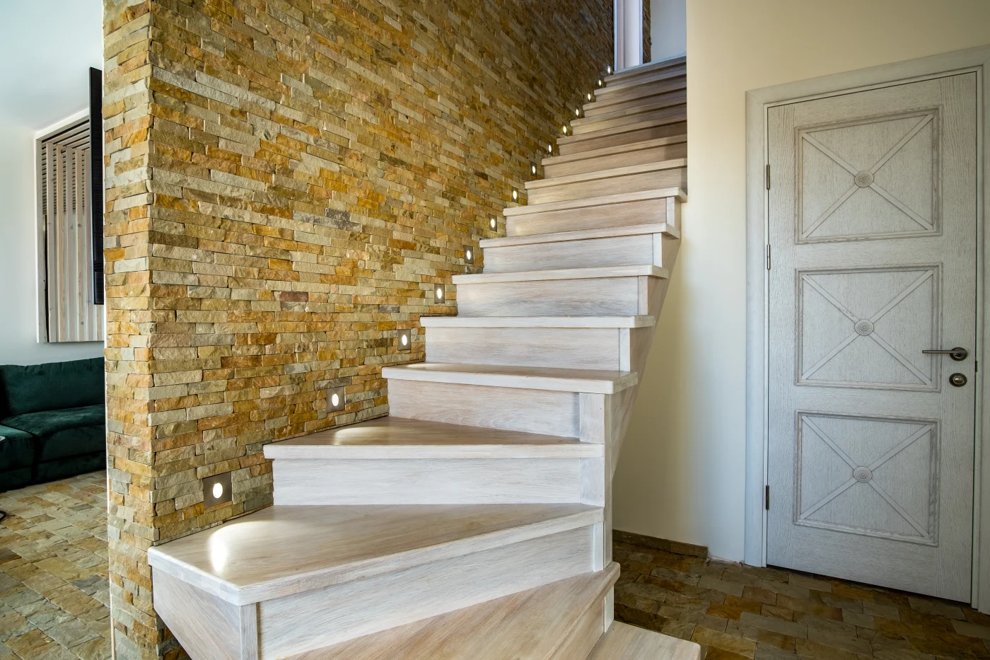 New stairs going up into home from basement, with lighting in the walls to illuminate each step