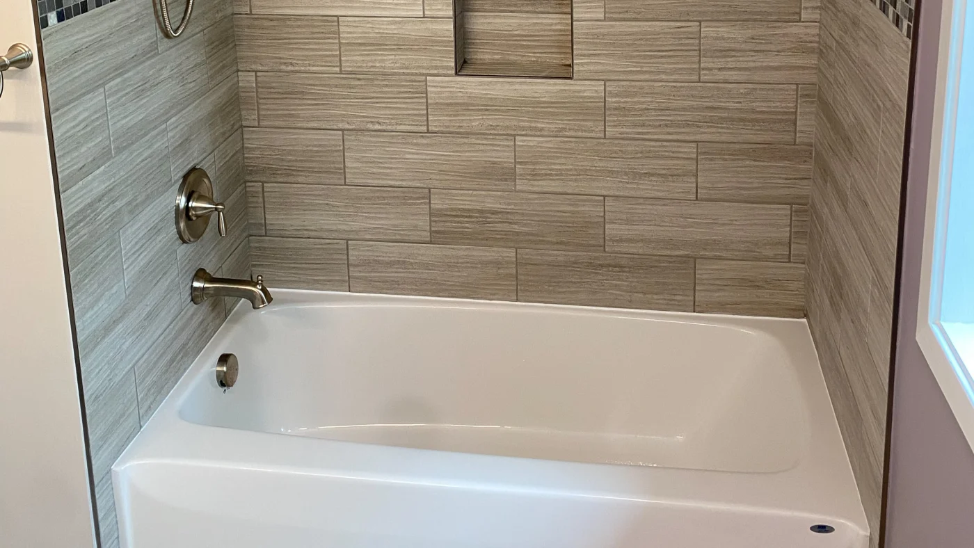 Great Full Bathroom Remodels In Georgetown, DE | Mast Contracting Close-up shot of a newly installed white bathtub in a shower with subway tile on the walls.