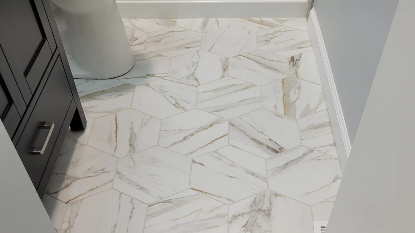 Great Interior Remodeling Company In Georgetown, DE | Mast Contracting Close-up shot of newly installed white hexagon tile on a bathroom floor.