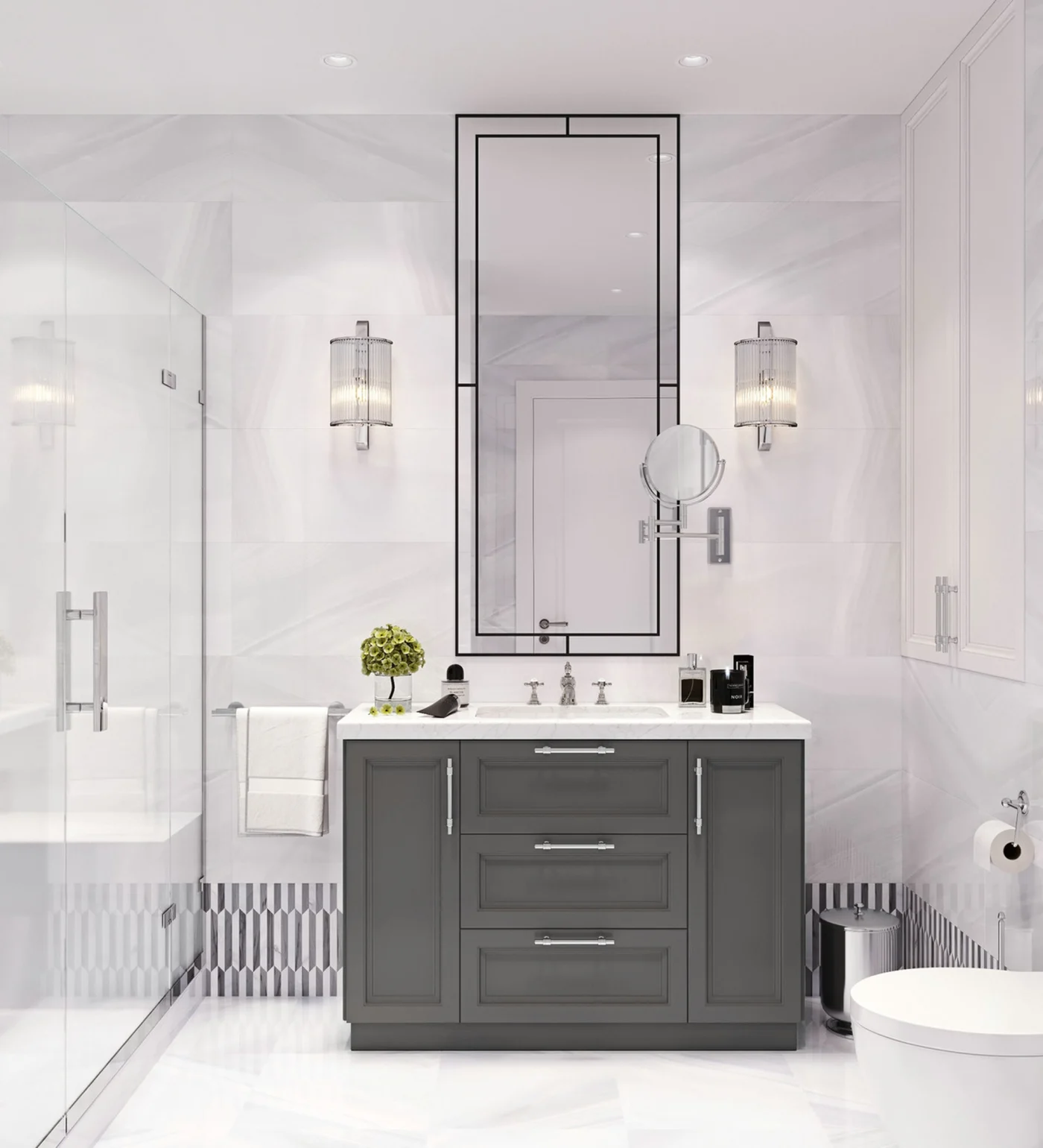 A white tiled bathroom with glass shower doors and a gray vanity.