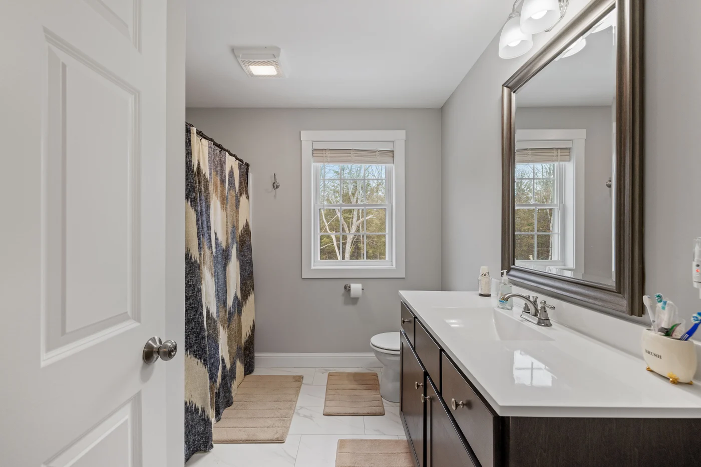 A white countertop and sink, with a black vanity cabinet installed in the bathroom