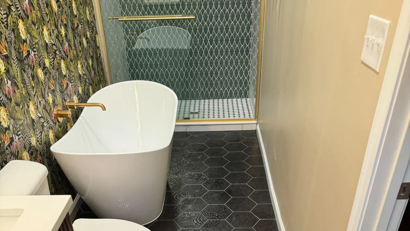 Best Bathroom Remodel Berlin Md Mast Contracting Newly remodeled bathroom with black hexagon tile flooring, a white porcelain tub, and a glass shower in the back.