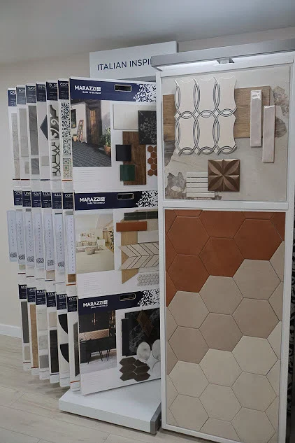Gracious Bathroom And Kitchen Remodeler In Rehoboth Beach, DE | Mast Contracting A portion of a showroom that has different styles of tile in different colors on display. The tile samples are mounted in a way that allows people to flip through them. There is a sign above the displays that says Italian Inspired.